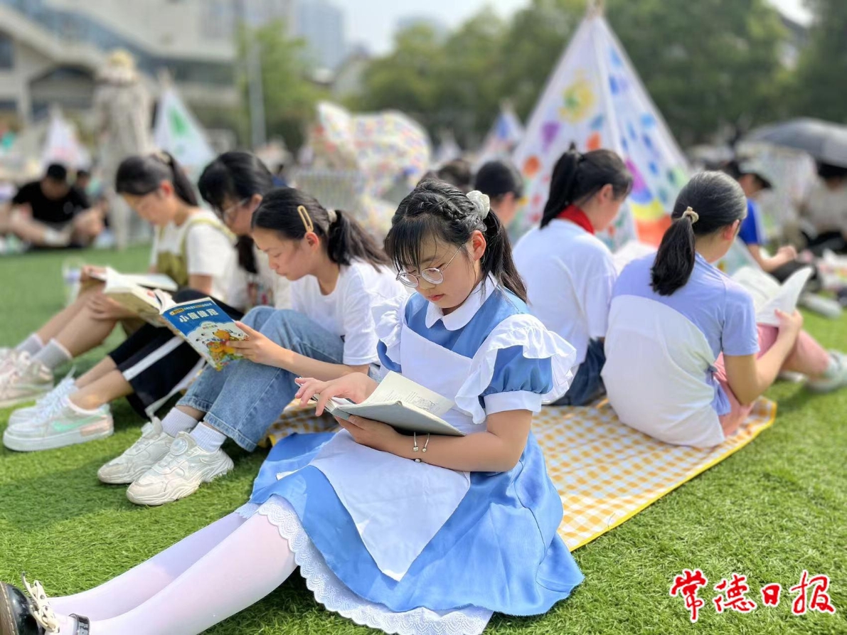紫菱小学开展草坪读书会，同学们在草坪上认真阅读。.jpg